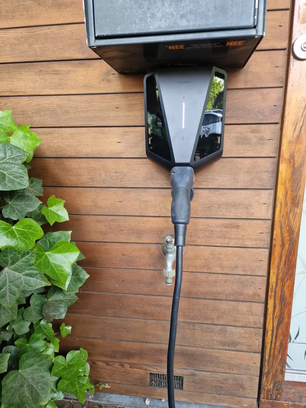 Easee laadpaal aan een houten gevel