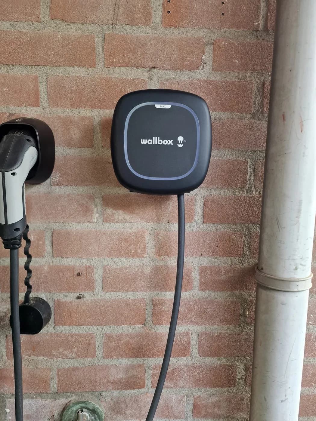 Wallbox laadpaal aan een bakstenen muur